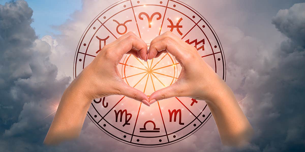 hands making heart symbol around zodiac wheel