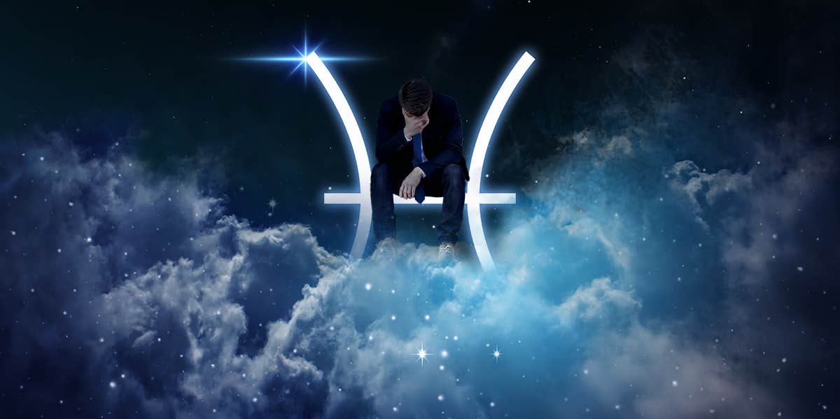 man sitting on pisces symbol in the sky