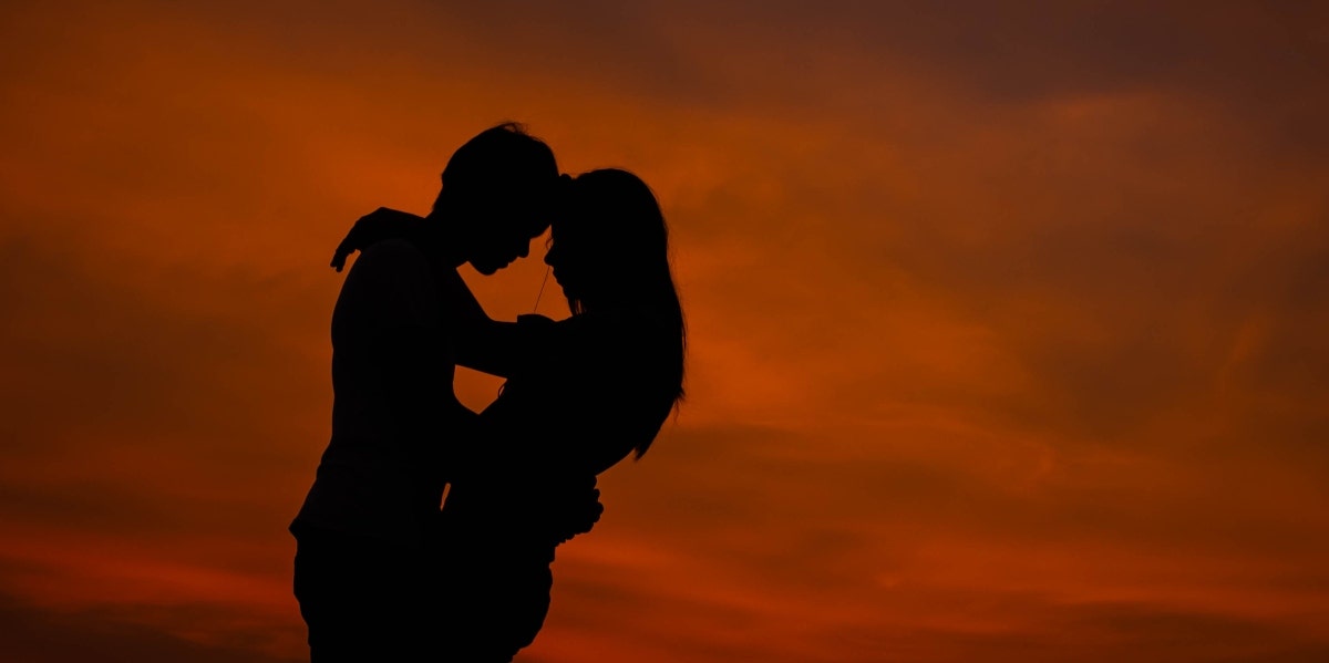 woma and man kissing in the sunset