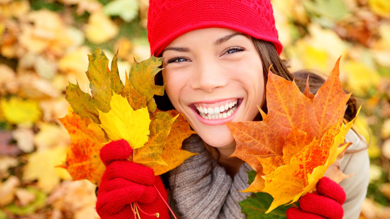 woman holding leaves in the fall