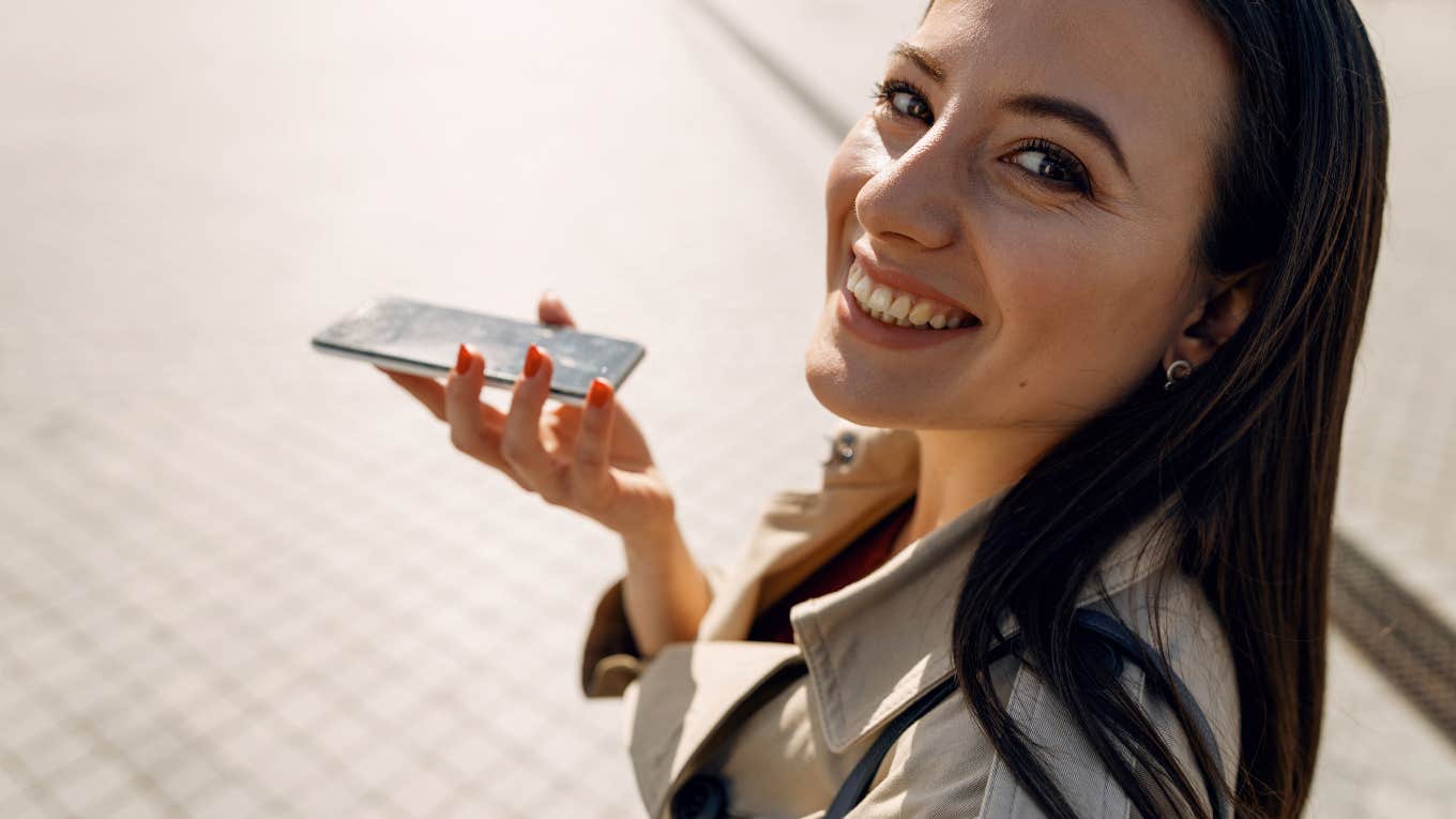 woman smiling while on cell phone