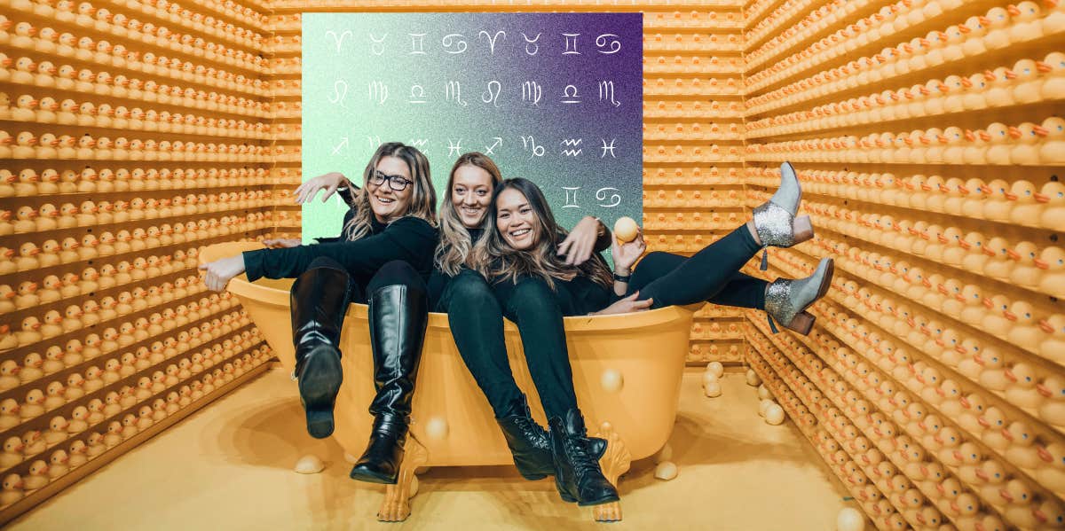 three girls in bathtub in front of zodiac signs