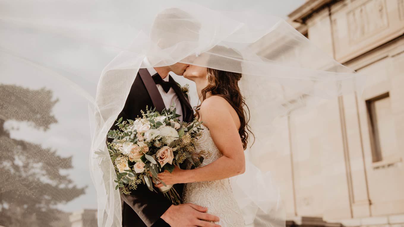 man and woman kissing on their wedding day