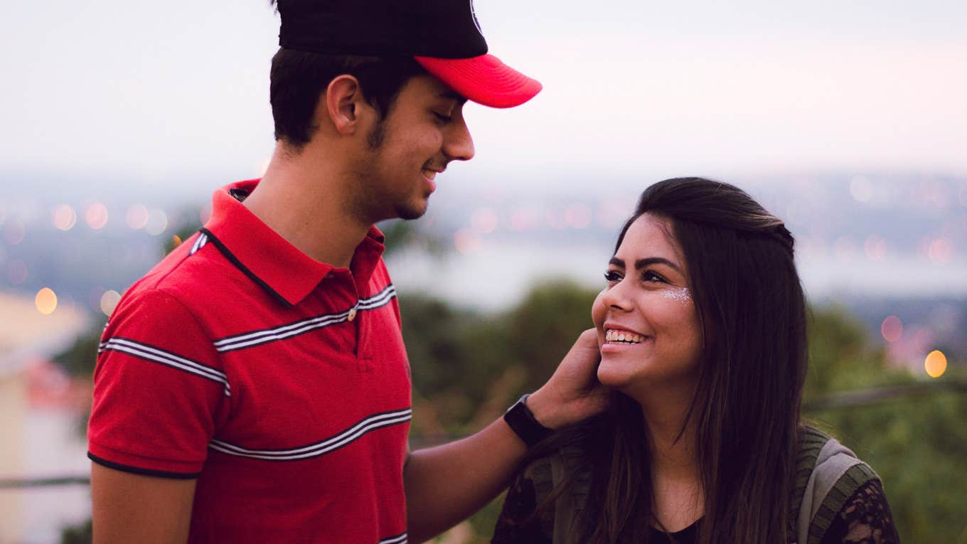 man touching woman's cheek