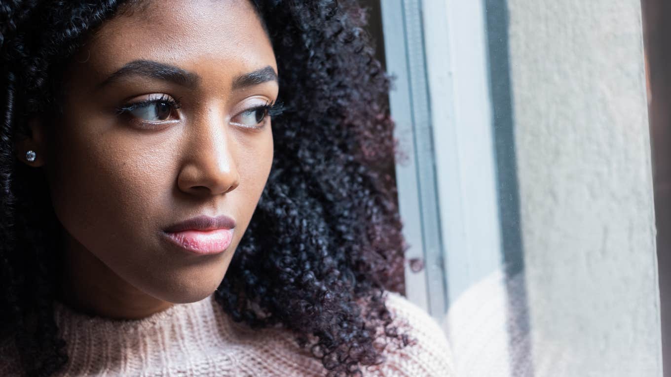 The 3 Zodiac Signs Signs With Rough Horoscopes Today, September 10 sad woman looking outside of a window
