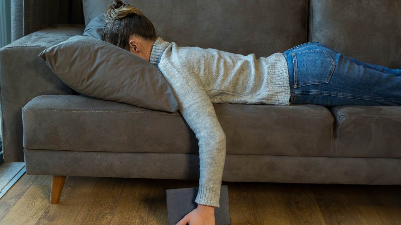 tired woman laying face down on sofa 
