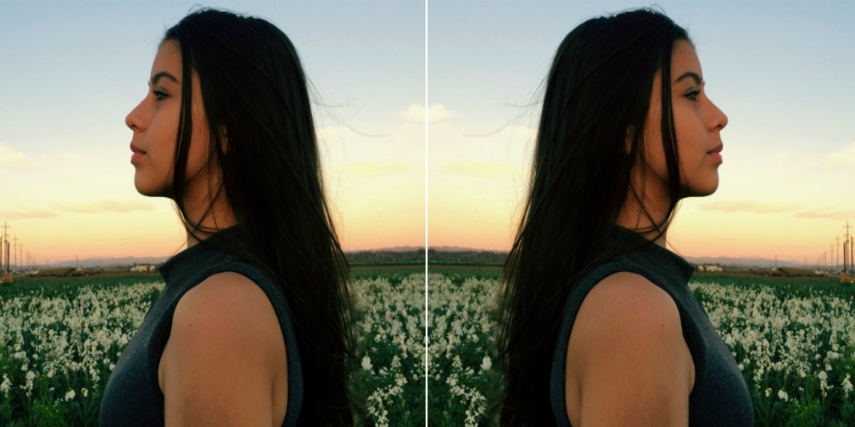 woman with long brown hair in a field of flowers