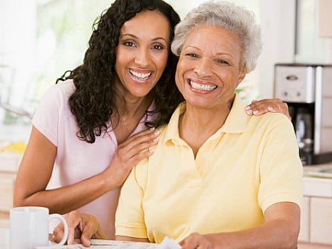 adult daughter with elderly mother smiling