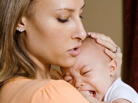 mother holding crying baby