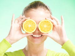 woman with orange halves on eyes