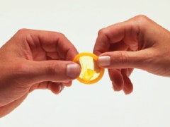 woman holding yellow condom