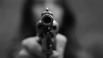 black and white gif of a woman holding a handgun with her fingers on the trigger