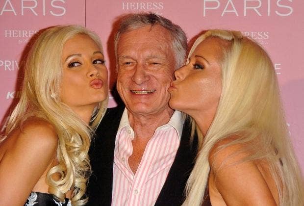 Holly Madison and Kendra Wilkinson kissing Hugh on the cheek