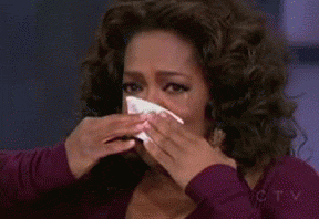 8 oprah winfrey crying into a kleenex tissue wearing a purple top