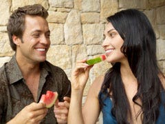 man and woman eating a watermelon
