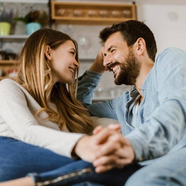 boyfriend and girlfriend smiling sitting holding hands