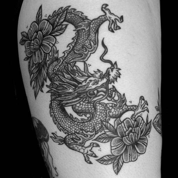 Floral dragon thigh tattoo