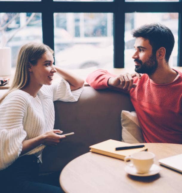 man and woman at a cafe table talking