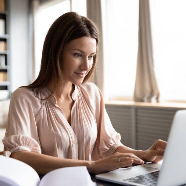 woman typing on laptop smiling