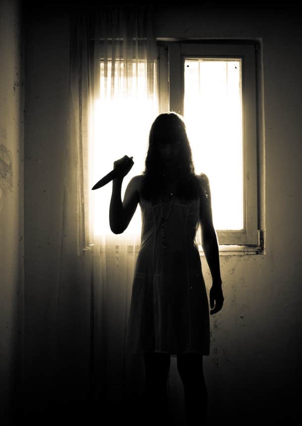 woman in shadows with knife