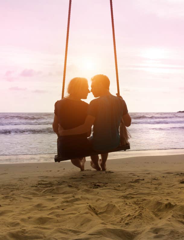romantic couple at beach on swing 