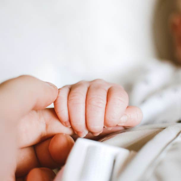 person holding infant's hand