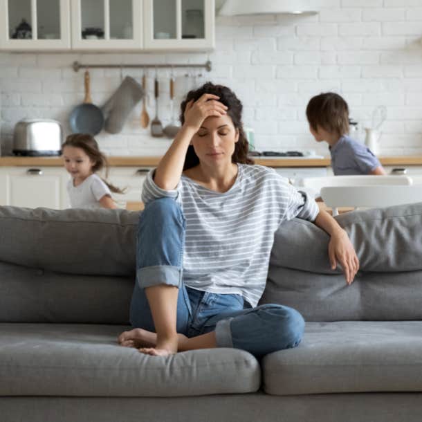 stressed mom on couch while two kids run around
