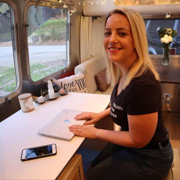 Happy photo of Heather facing the camera while working inside her Airstream