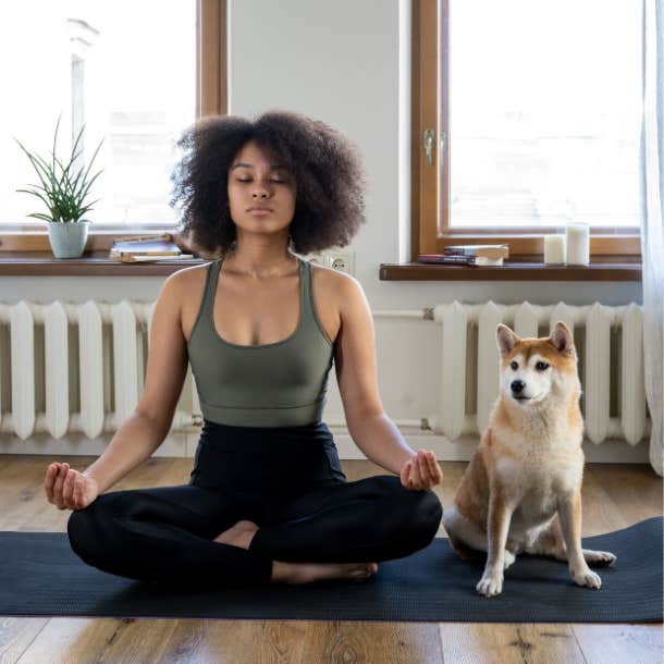 woman meditating next to dog