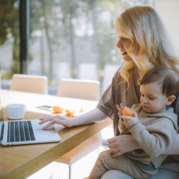 woman working on laptop with baby on her lap