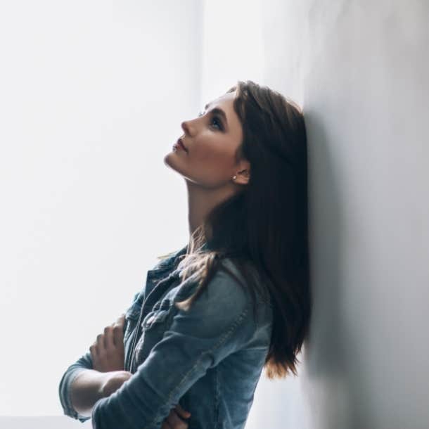 upset woman leaning against wall