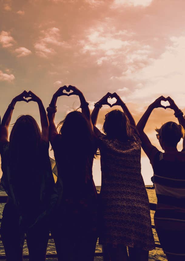 group of women heart hand to the sunset