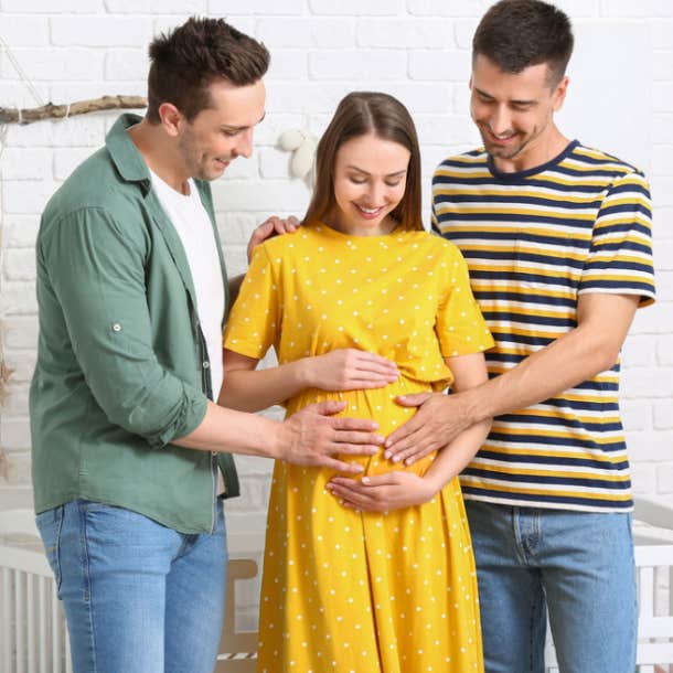 Gay male couple with a pregnant surrogate at home.