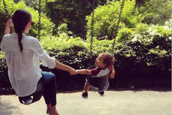 Mother and child swinging together