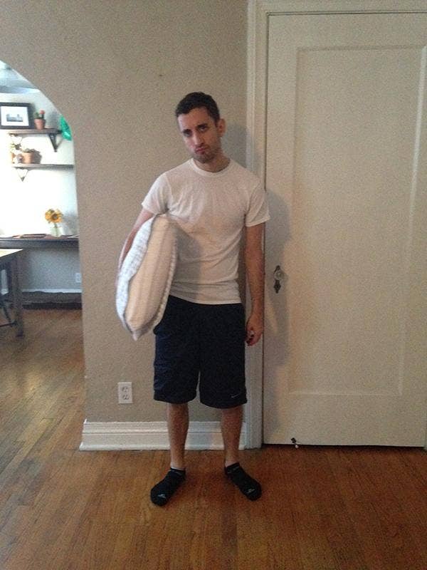 man with white t-shirt, shorts and a pillow