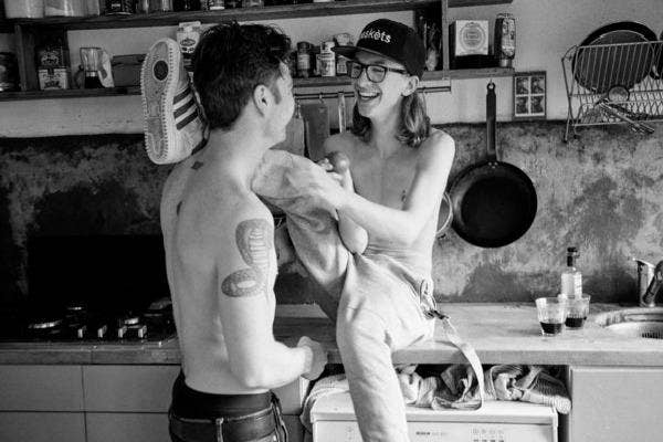 Couple laughing in the kitchen.