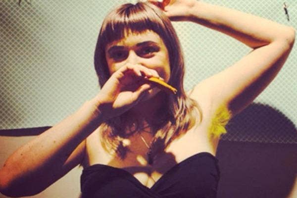 Woman with bushy yellow underarm hair.