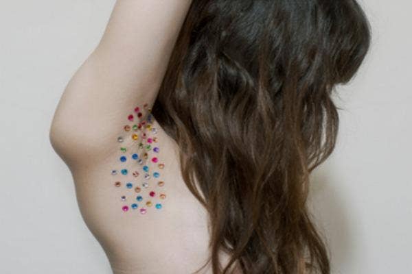 Many different colored fake gemstones body art.