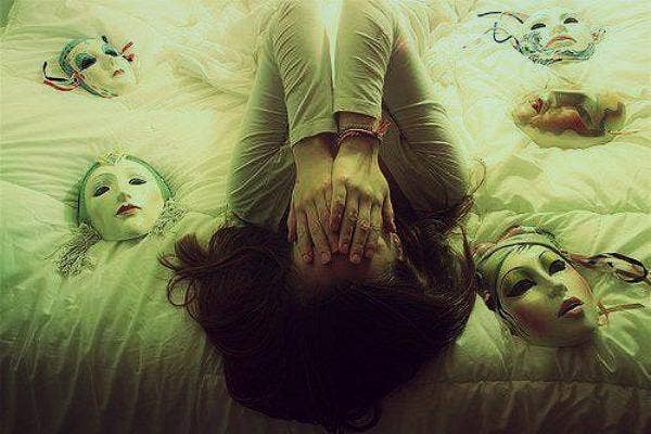 woman hides face on bed of masks