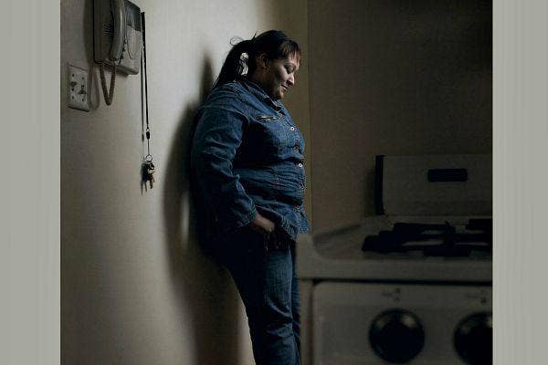 Woman leaning against wall.