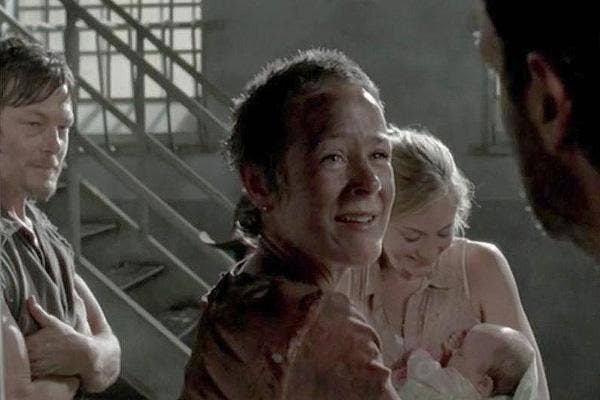 Melissa McBride as Carol Pelletier holding Judith in the prison on The Walking Dead AMC