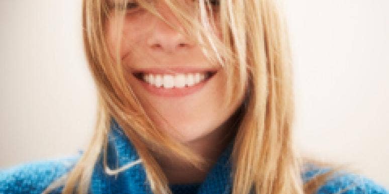 7 Happiness Boosters To Try Right Now Smiling woman blue sweater
