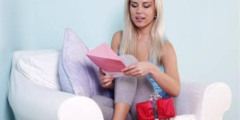 Blonde woman reading card to accompany gift Blonde woman reading card to accompany gift