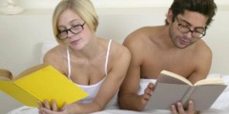 Couple wearing glasses and reading in bed