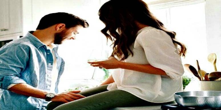 Woman drinks wine while man cooks. Woman drinks wine while man cooks.