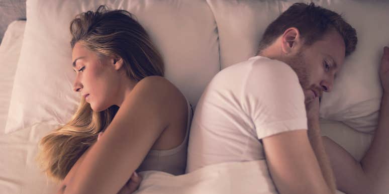 10 Sneaky Signs Jealousy Is Destroying Your Relationship couple facing away from one another in bed