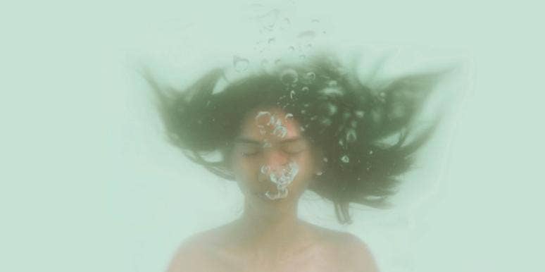 Signs Your Past Childhood Trauma Is Making You Physically Sick woman floating in water