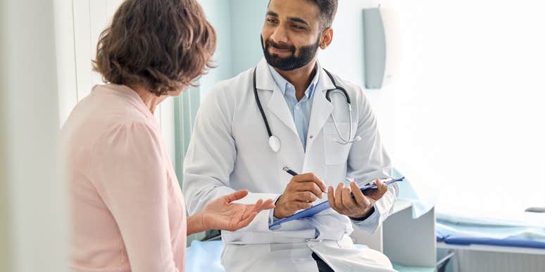  male doctor consulting patient and filling form at consultation