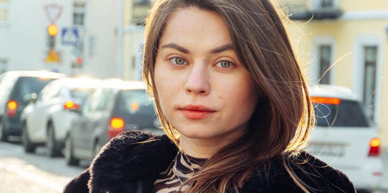 woman walks the streets full of cars in a black fur coat