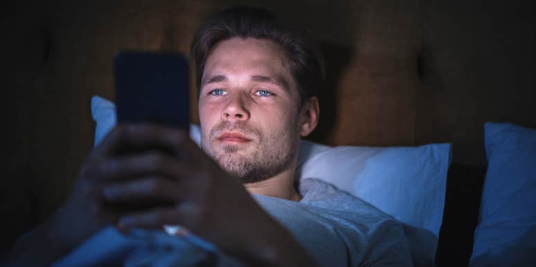 man scrolling on his phone in bed before falling asleep